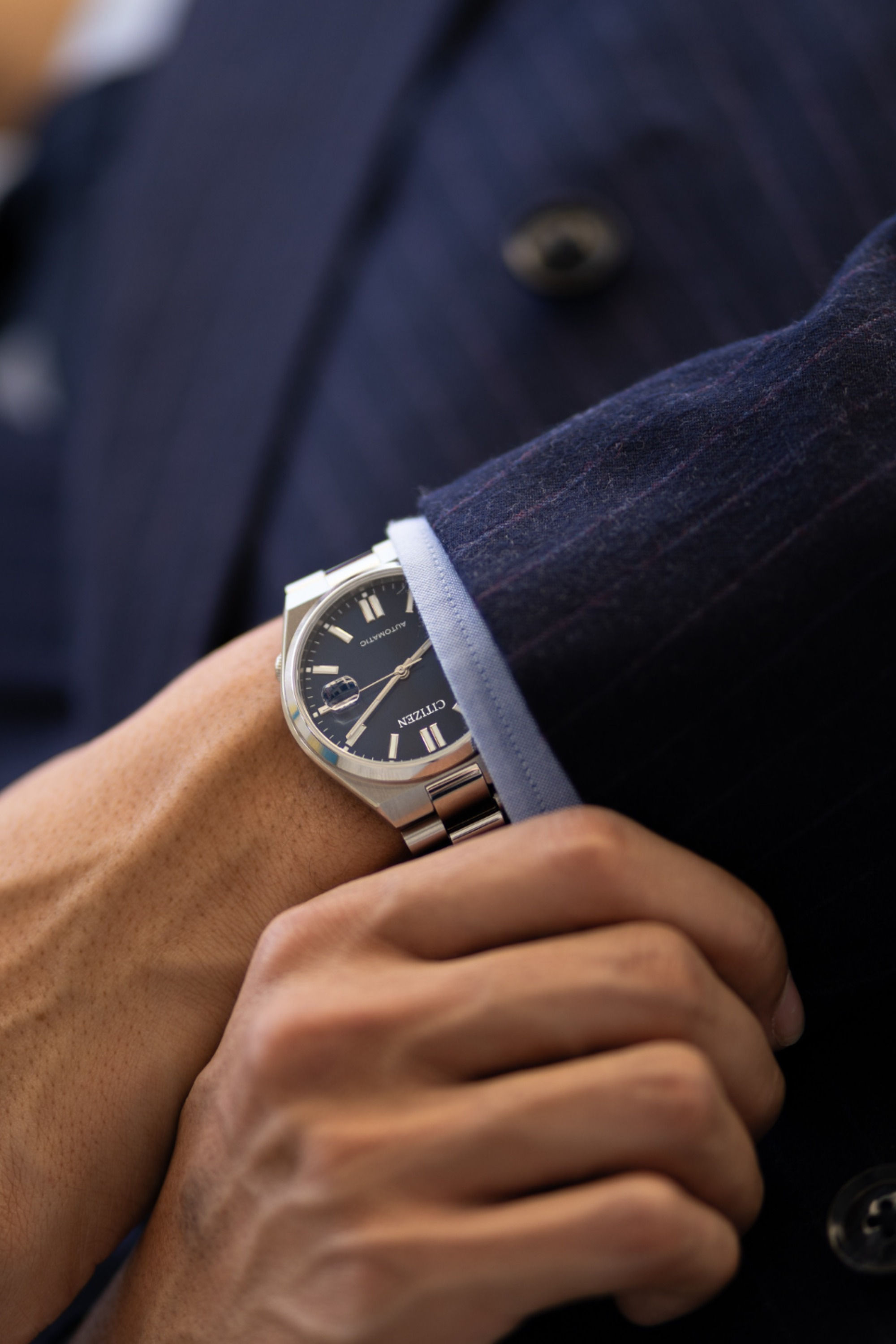 Citizen silver and navy blue wristwatch — automatic movement, date window, silver-toned indices, three-hand display, link bracelet, fluted bezel
