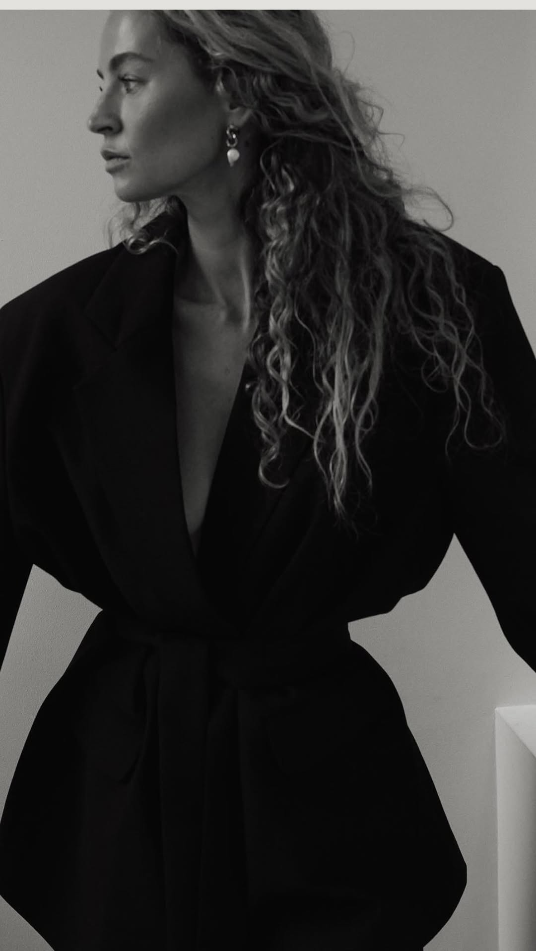 luxury black blazer — wide lapel, deep V-neck, self-tie waist belt, dropped shoulders