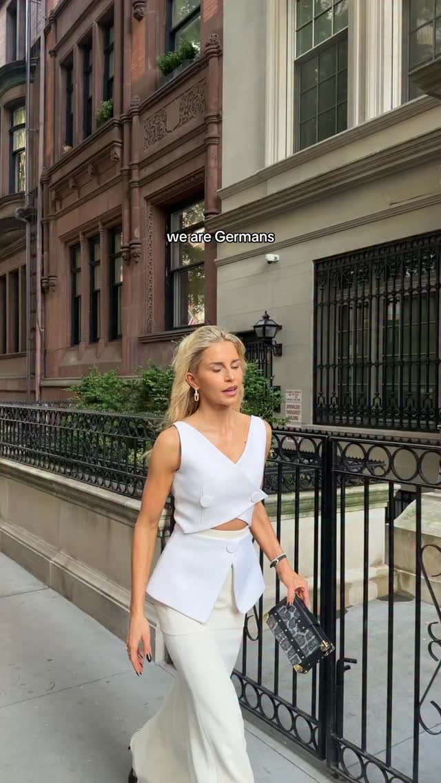 luxury off-white two-piece set — sleeveless V-neck top, asymmetrical peplum, decorative buttons, cropped waist cutout, high-waisted wide-leg trousers