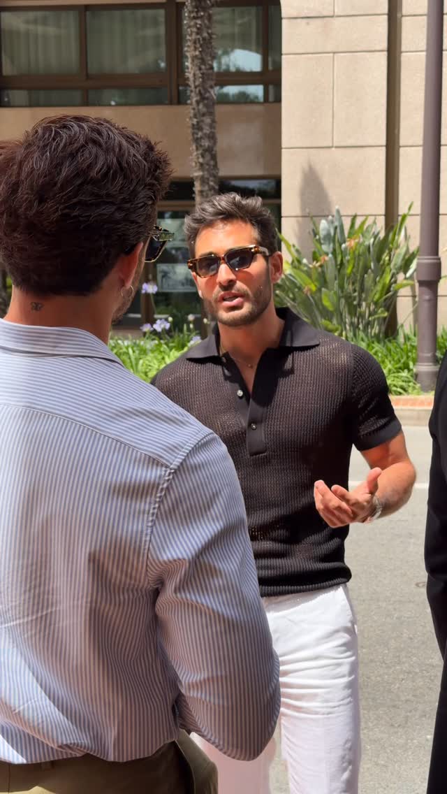 casual black polo shirt — short sleeve, spread collar, three-button placket, ribbed hem and cuffs, open knit texture