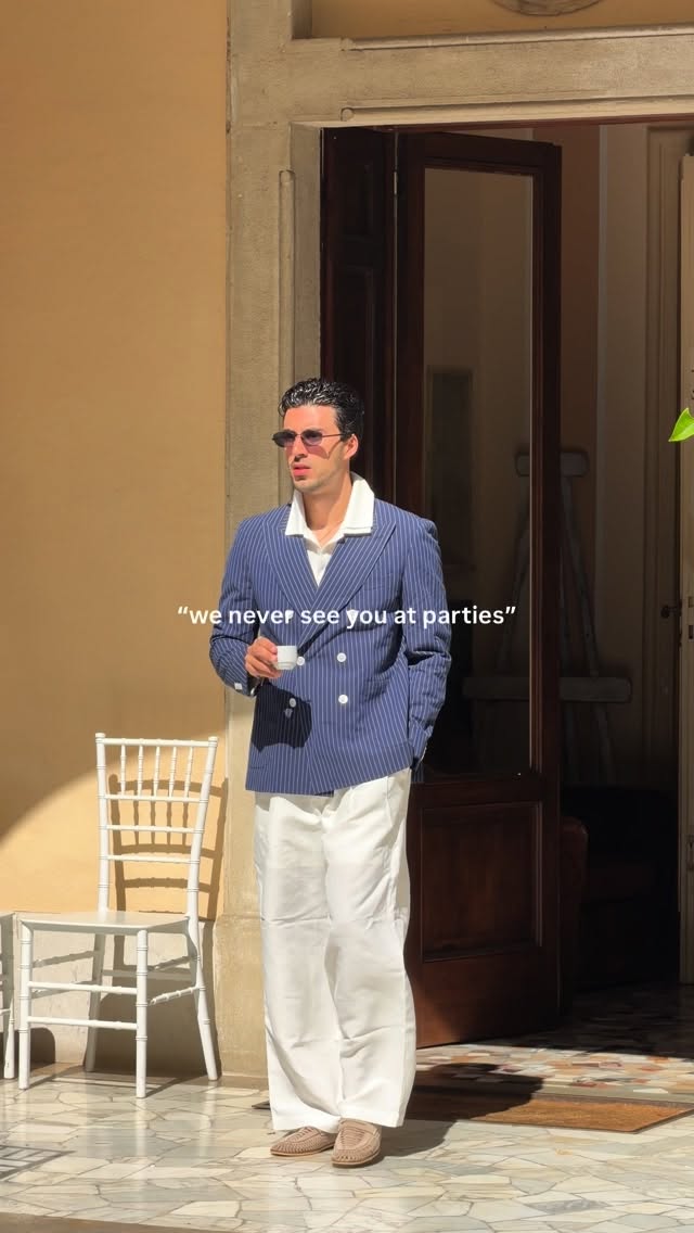 casual navy blue with white pinstripes double-breasted blazer — peak lapels, four-button double-breasted closure, patch pockets