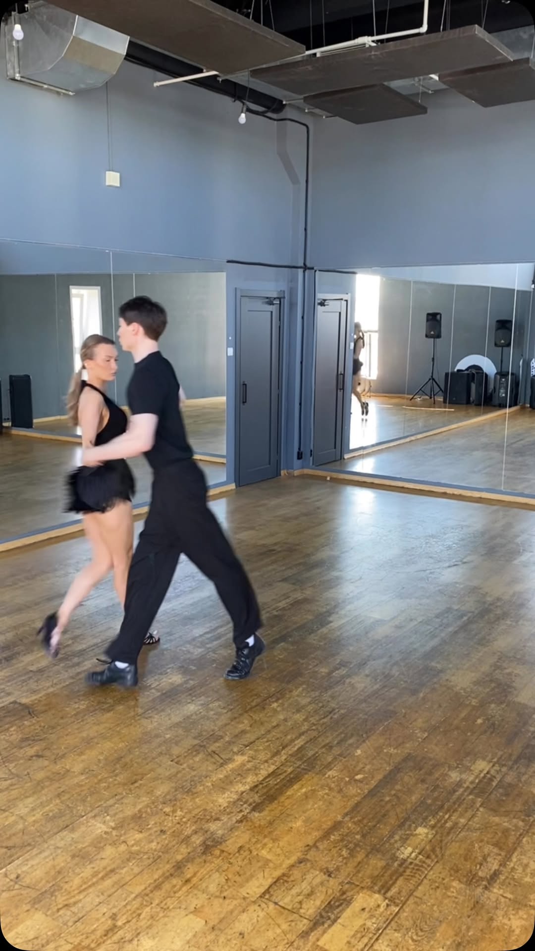dancewear black two-piece dance outfit — halter neck top, open back, short fringed skirt, high-waisted skirt