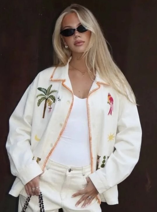 looks like contemporary designer overshirt relaxed boxy cream white cotton twill pointed collar, button-front closure tropical embroidered motifs bohemian, resort wear, contemporary