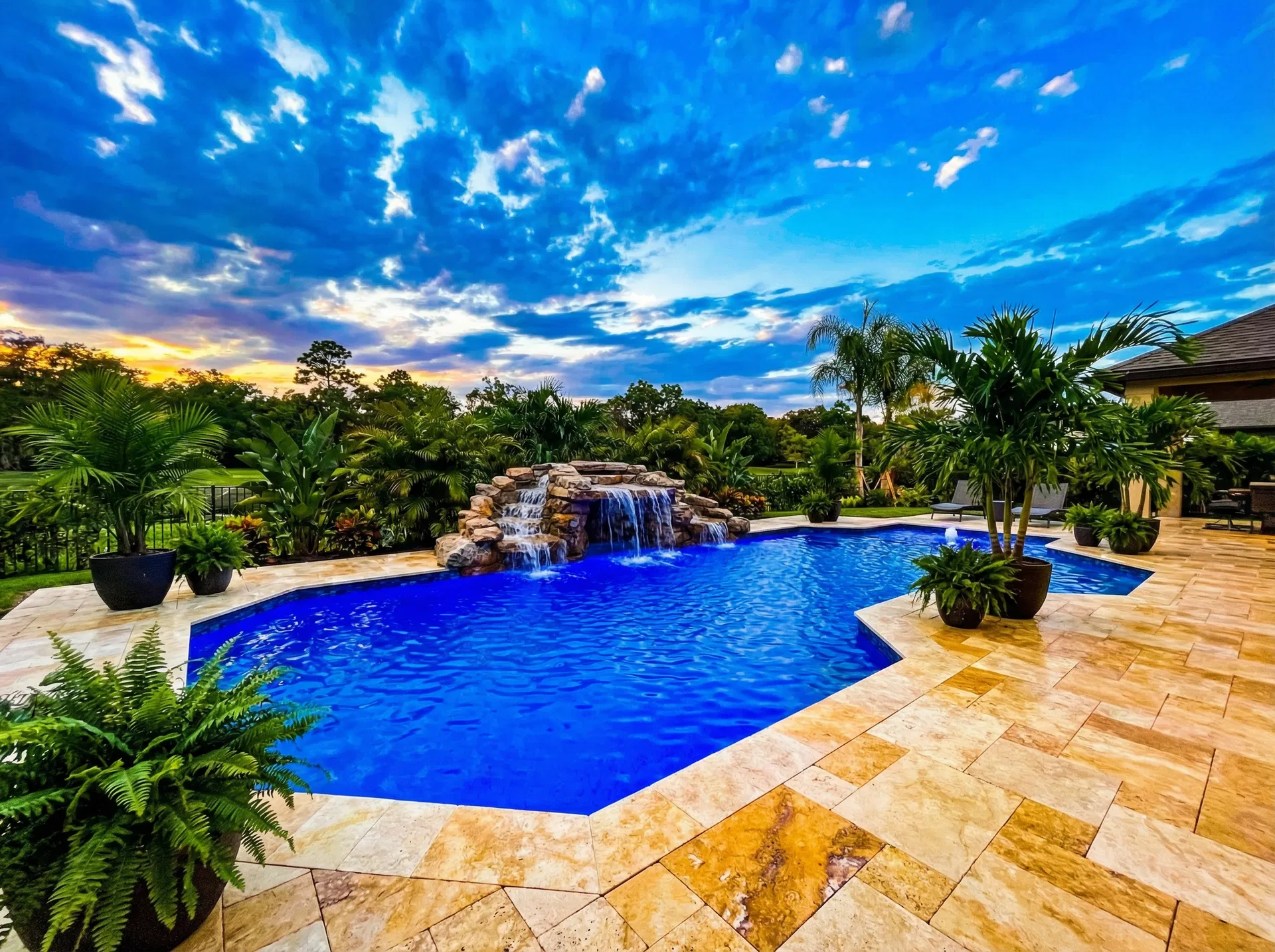 Resort-style pool remodel in Allen TX with water features and travertine deck