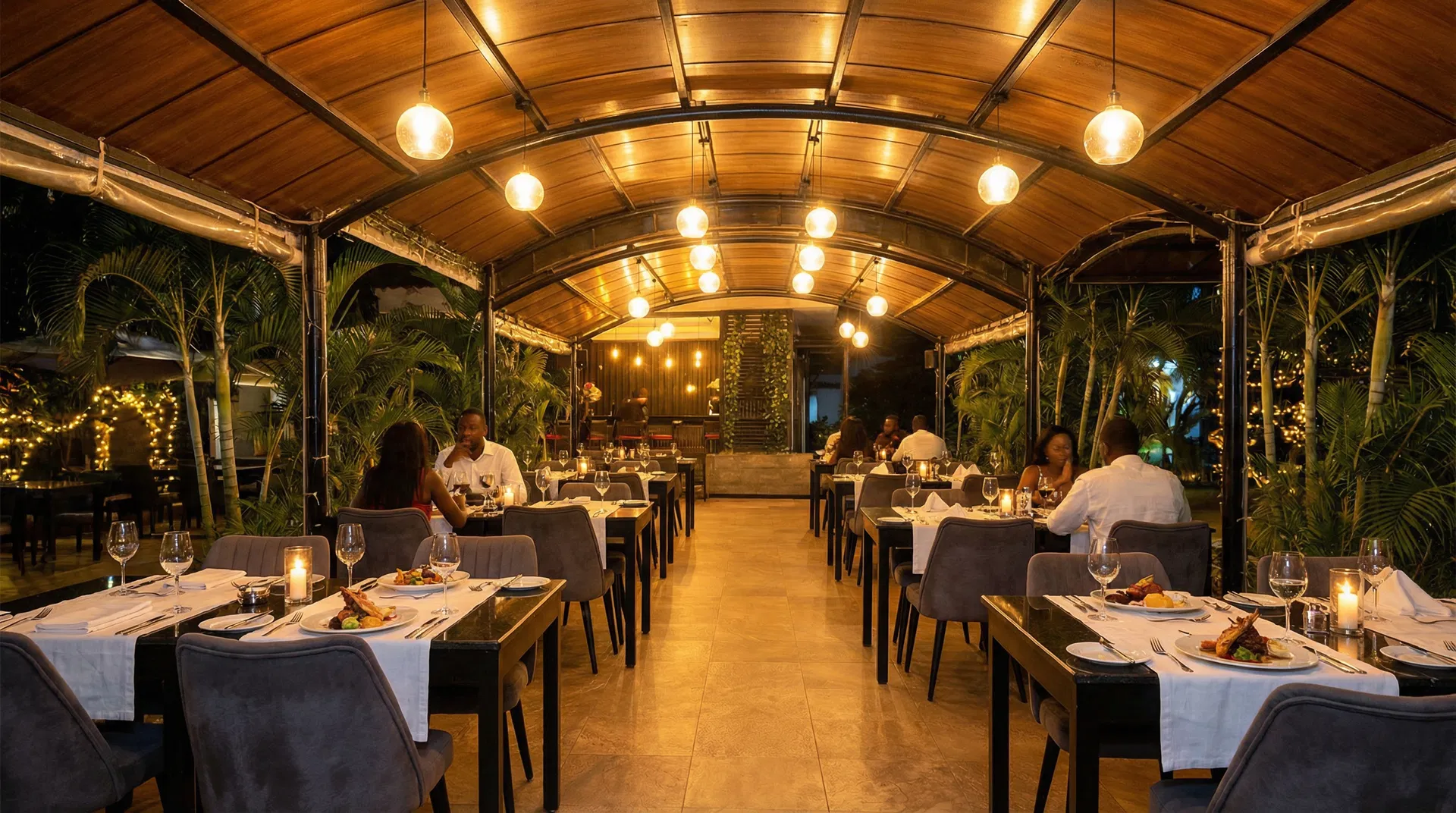Citro Abuja covered outdoor garden terrace with tropical greenery and ambient lighting