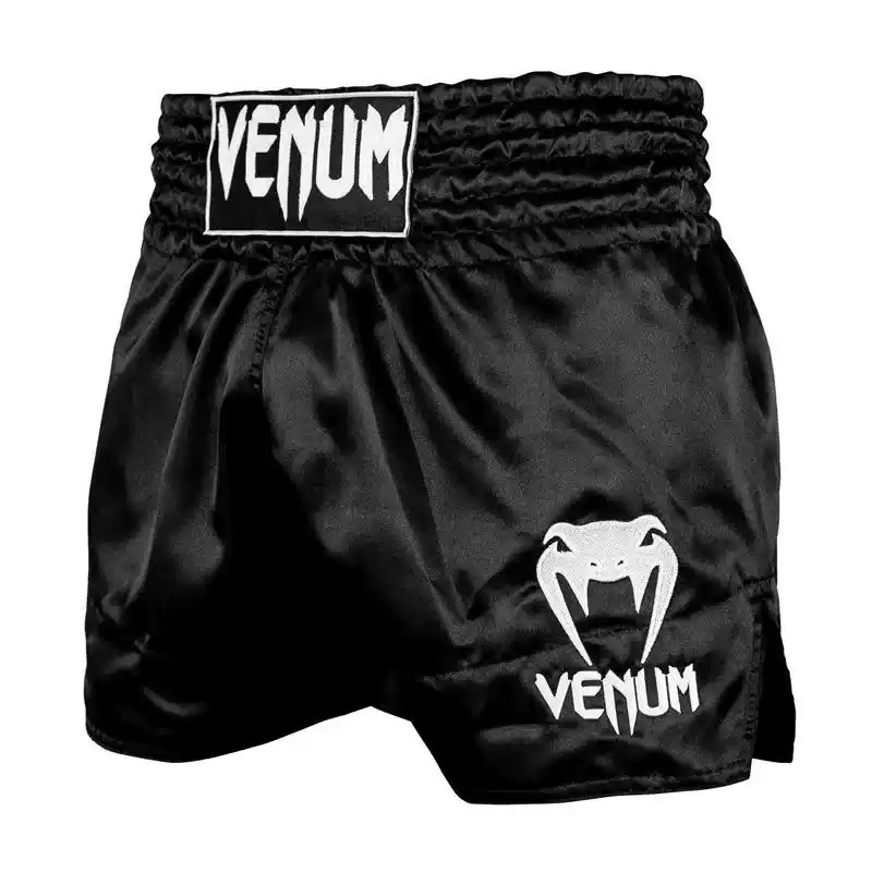 經典黑白緞面泰拳短褲，配有醒目 Venum 標誌與高開衩剪裁