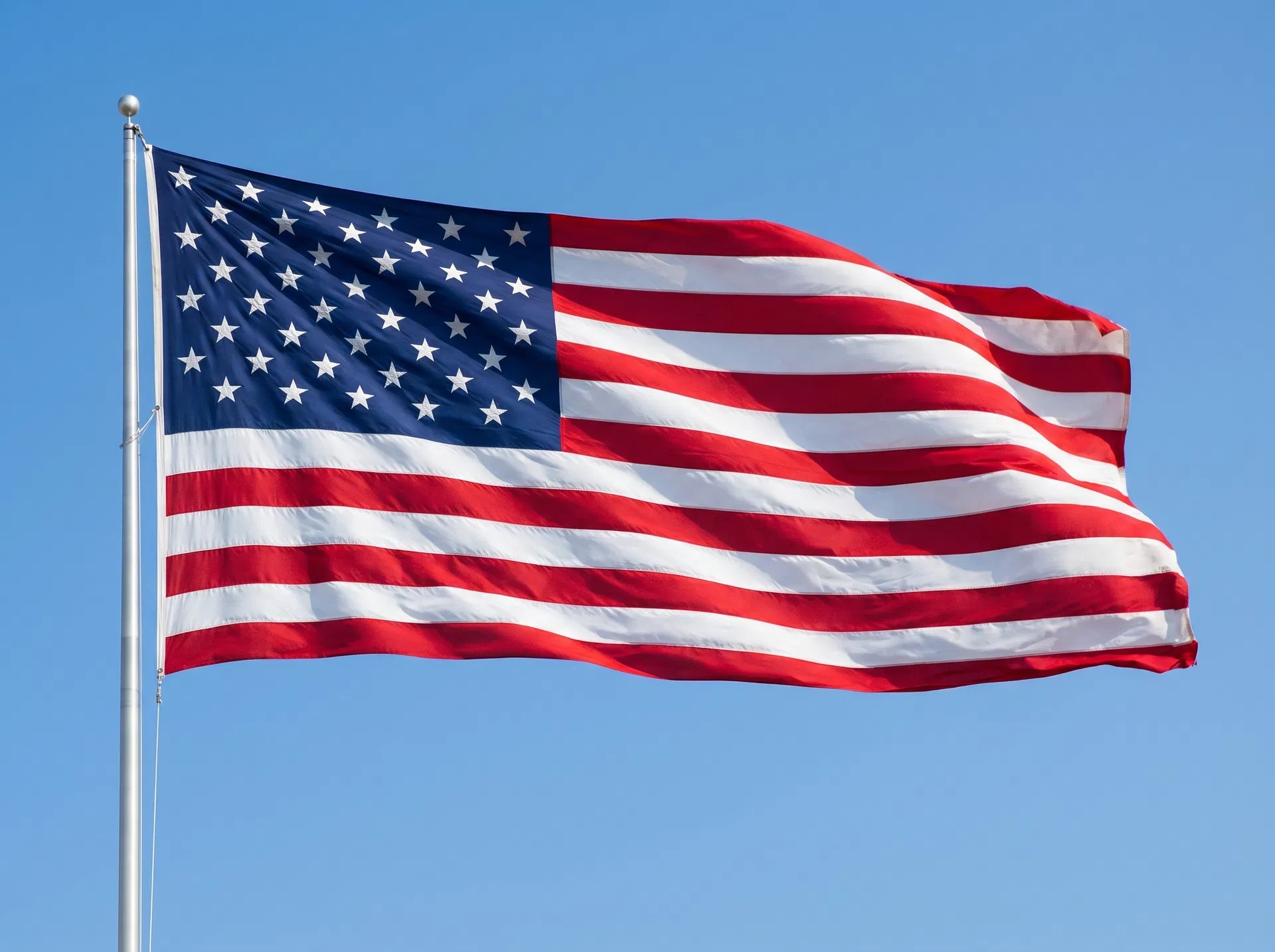 American flag flowing in the wind against a blue sky