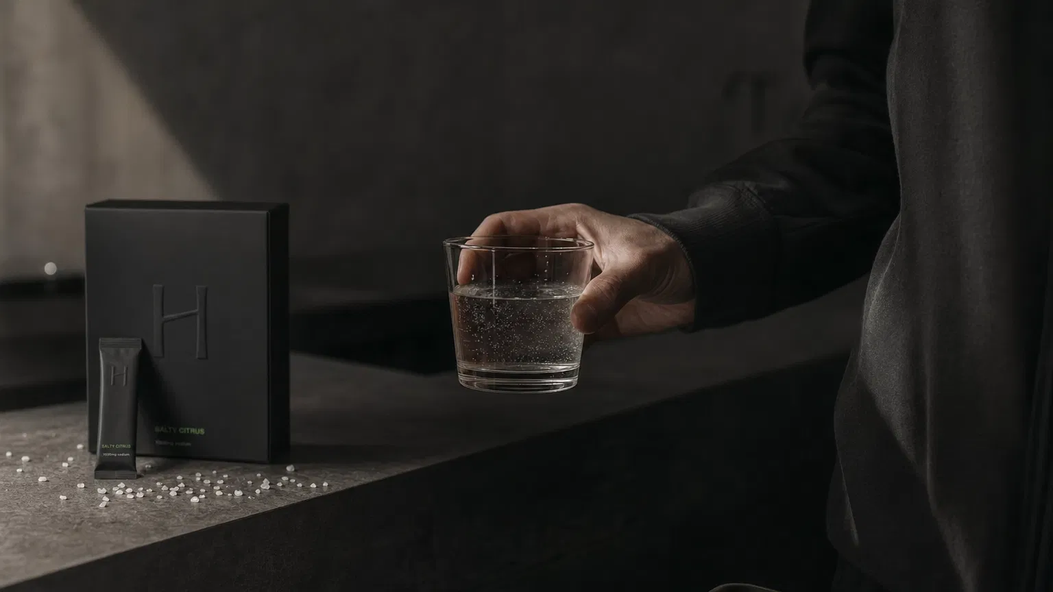 Person holding a glass of water with HELK metabolic hydration