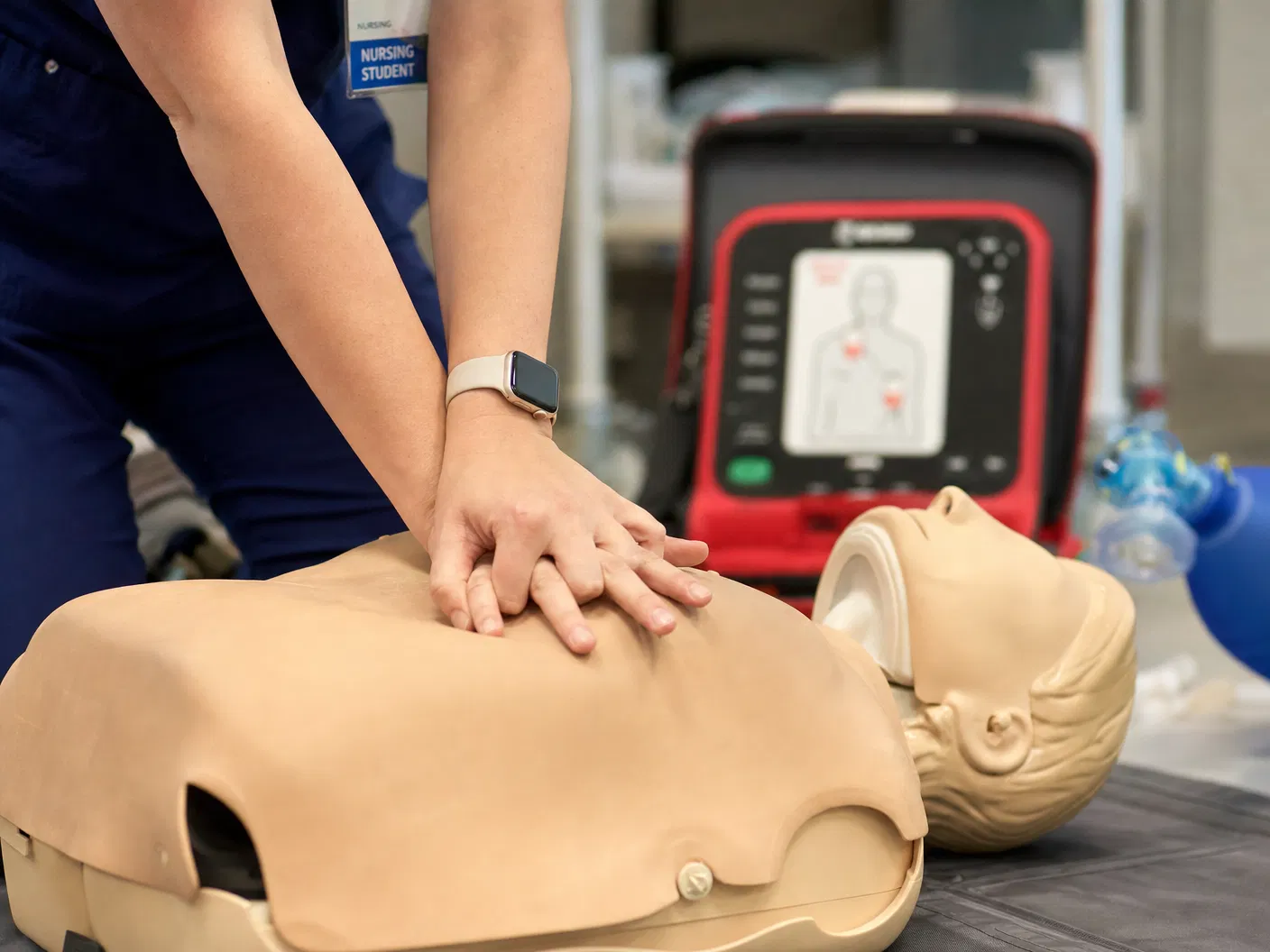 CNA student practicing CPR on training mannequin during certification class