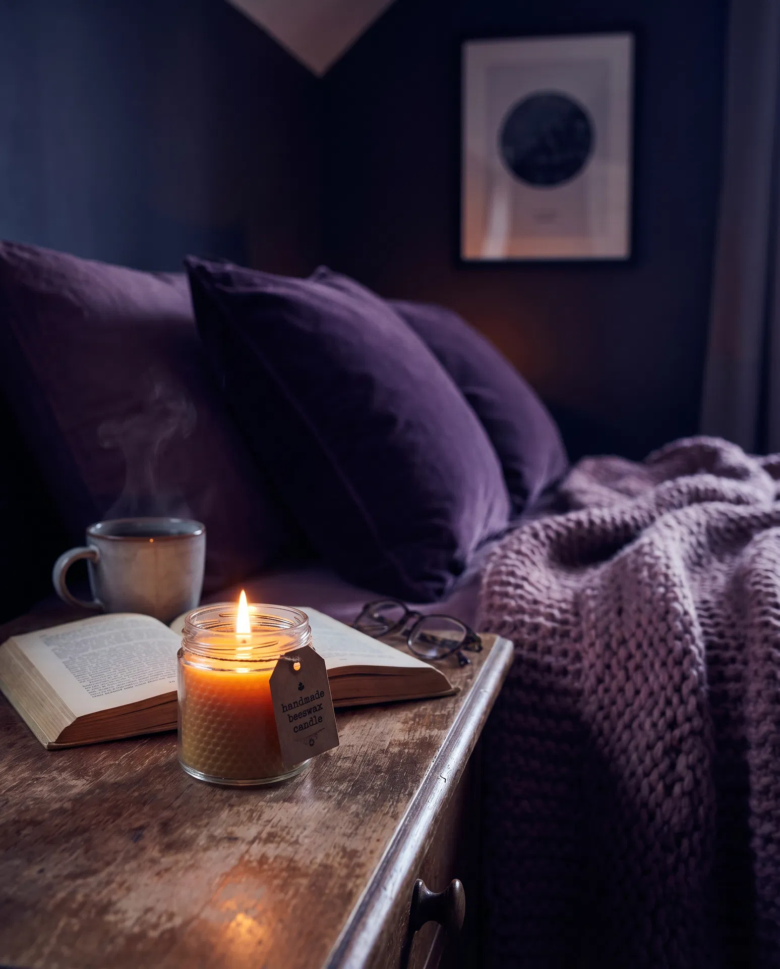 Lit candle on bedside table with book