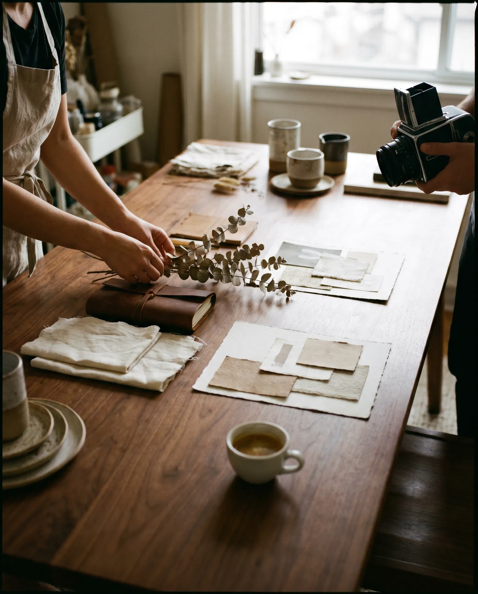 The Studio Creative Co at work — flatlay of brand boards, mood swatches, and a medium format camera.