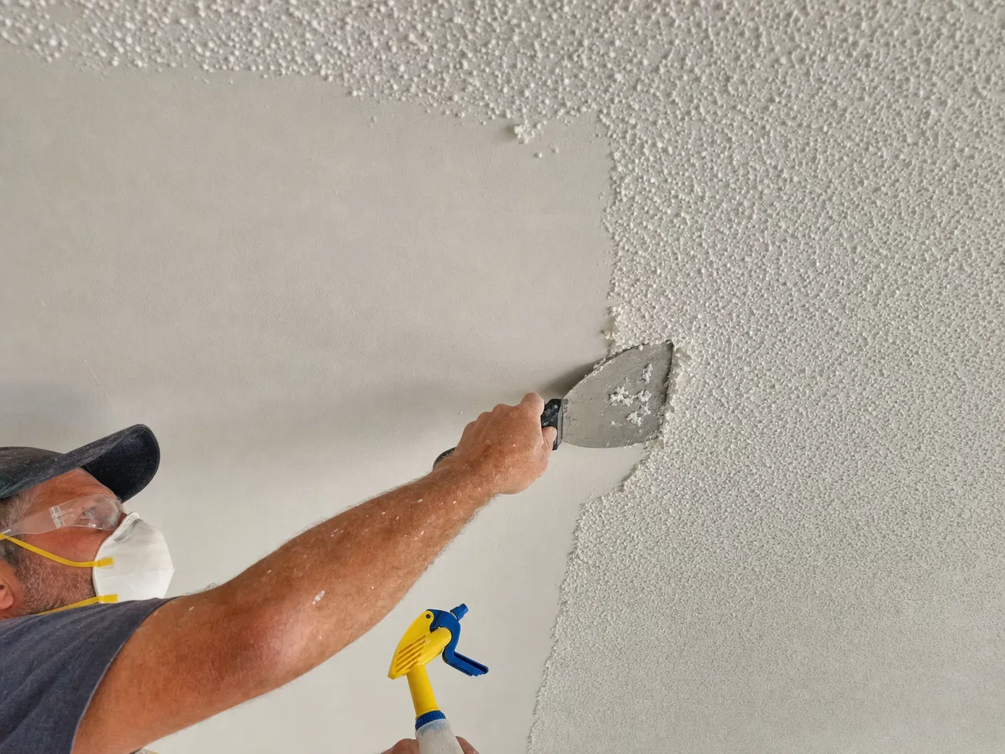 Popcorn Ceiling Removal Service — Drywall Texture Pros | Ocala, FL Contractor removing popcorn ceiling texture in an Ocala, FL home revealing smooth drywall underneath