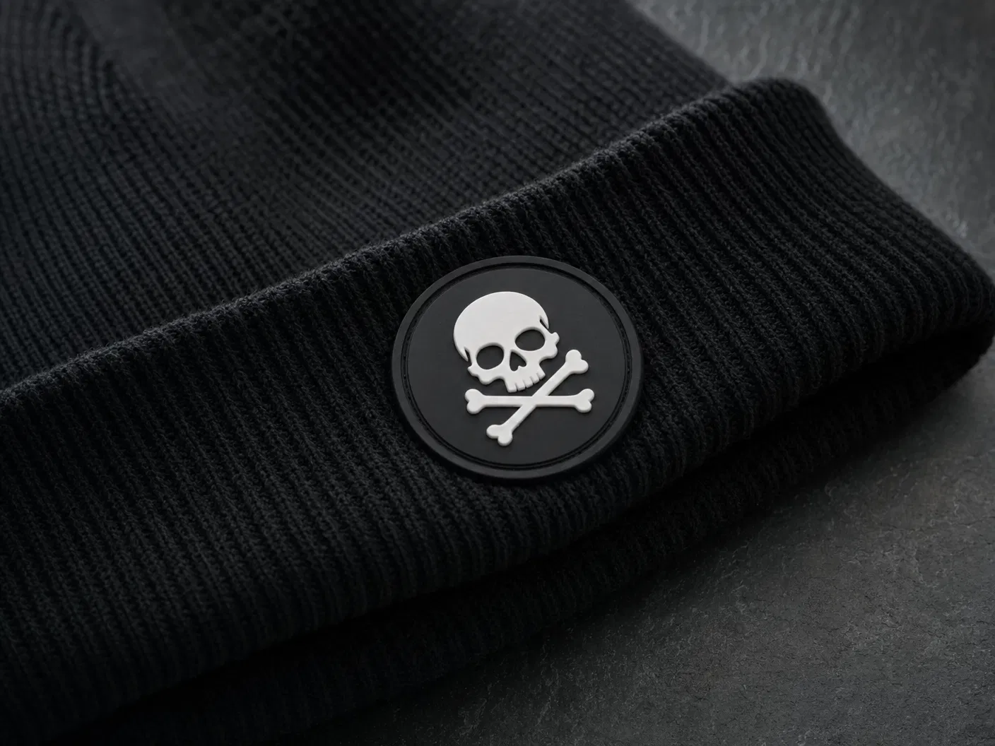 Rubber PVC patch with skull logo on black beanie