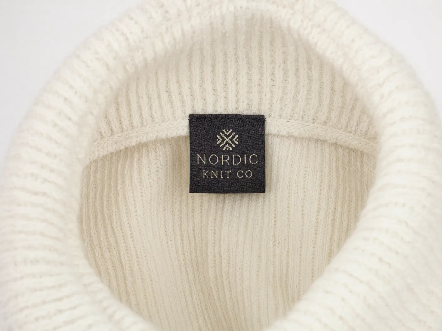 Woven brand label inside cream beanie