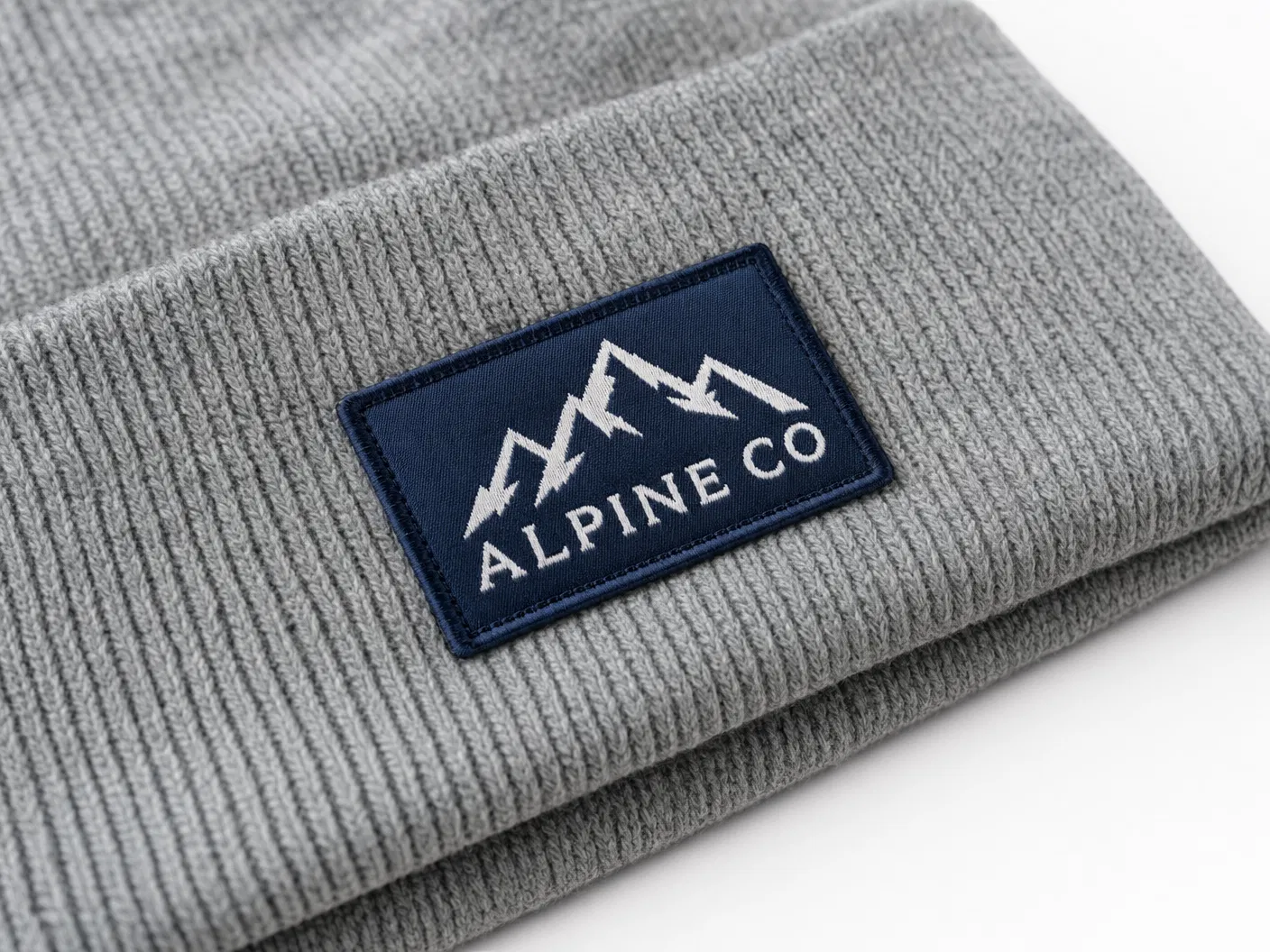 Woven patch with Alpine CO logo on heather grey beanie