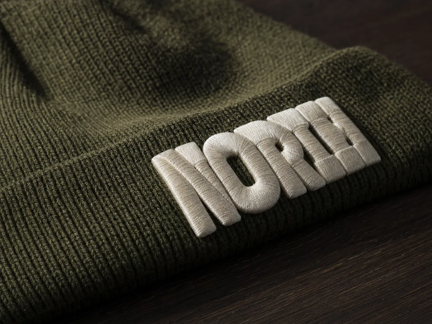 3D puff embroidery NORTH lettering on olive green beanie