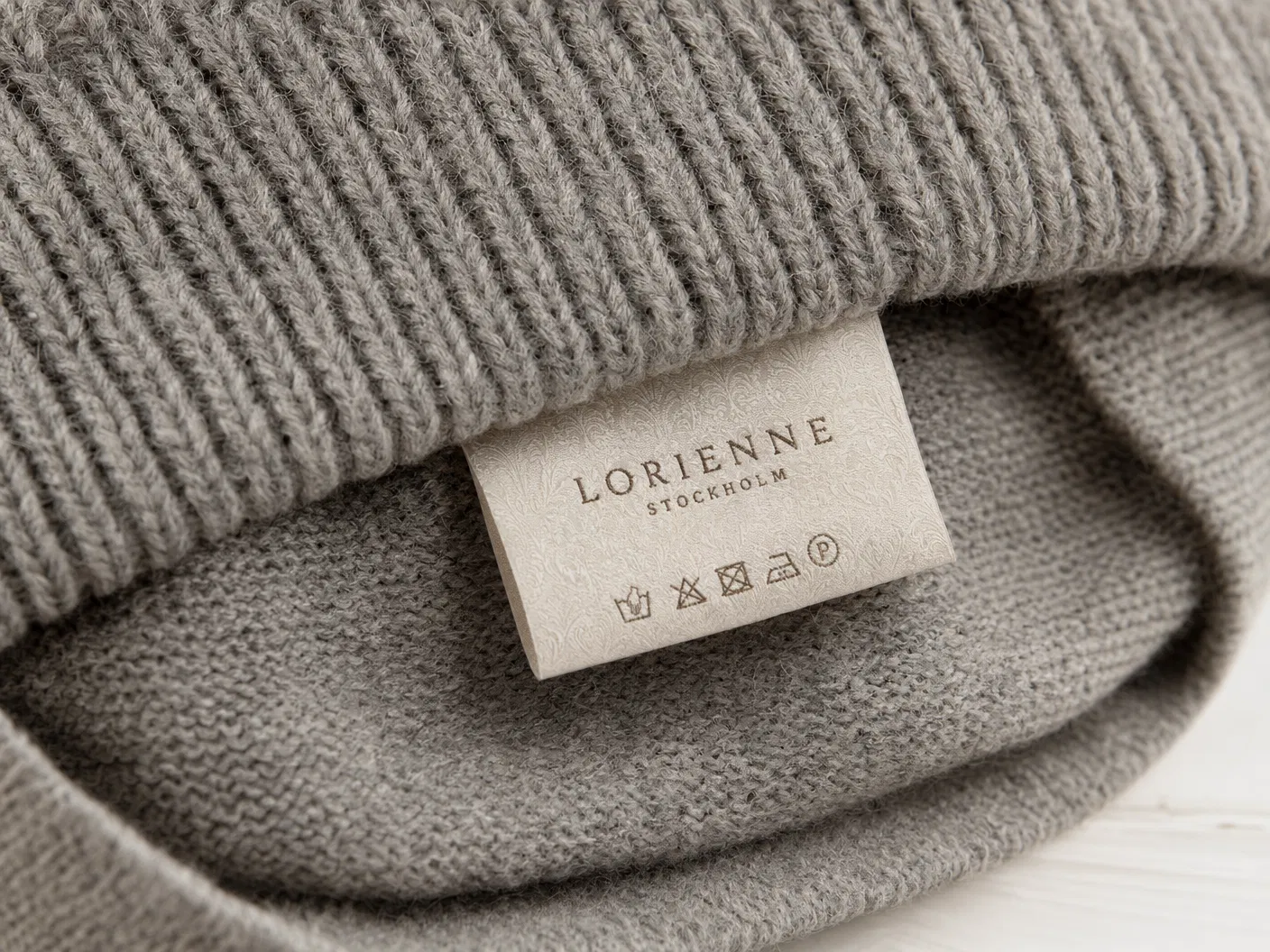 Woven brand label inside grey knit beanie
