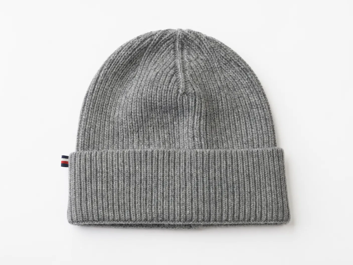 Heather grey cuff beanie with flag label on white surface