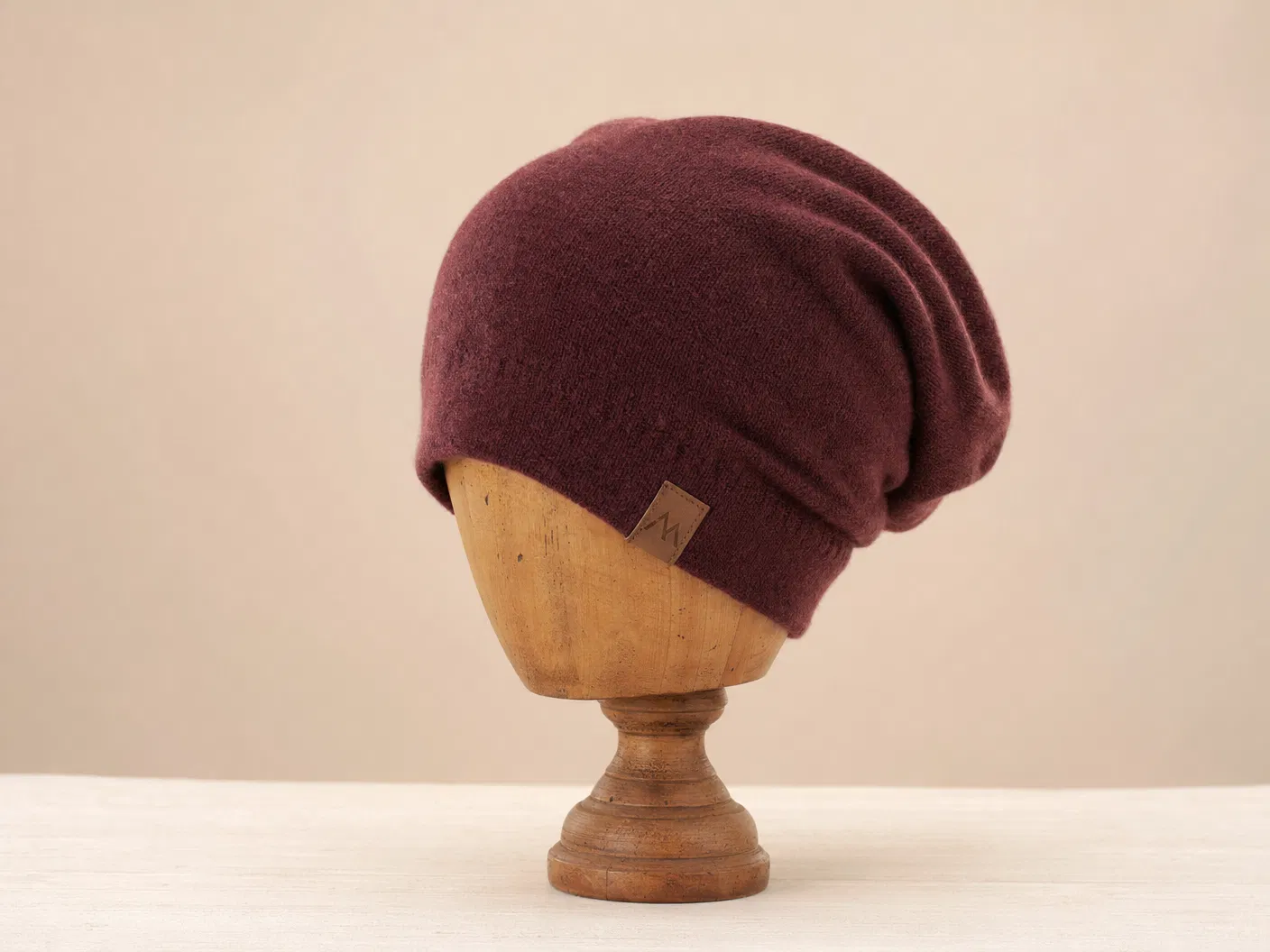 Burgundy slouch beanie on wooden mannequin head
