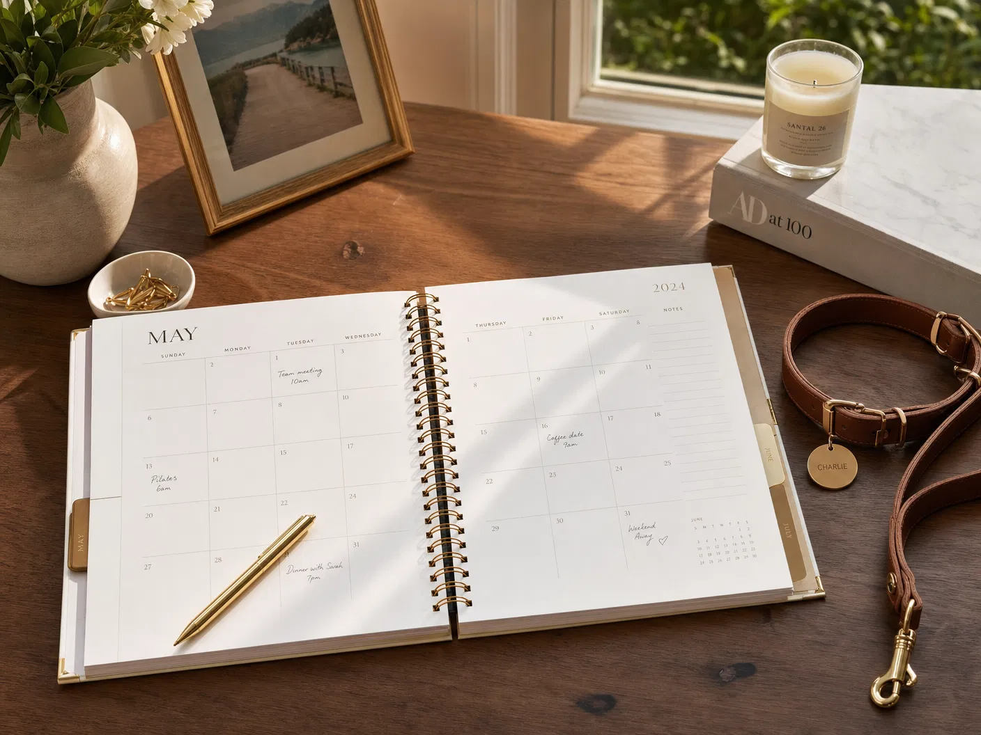 Elegant calendar planner with a gold pen and dog leash beside it