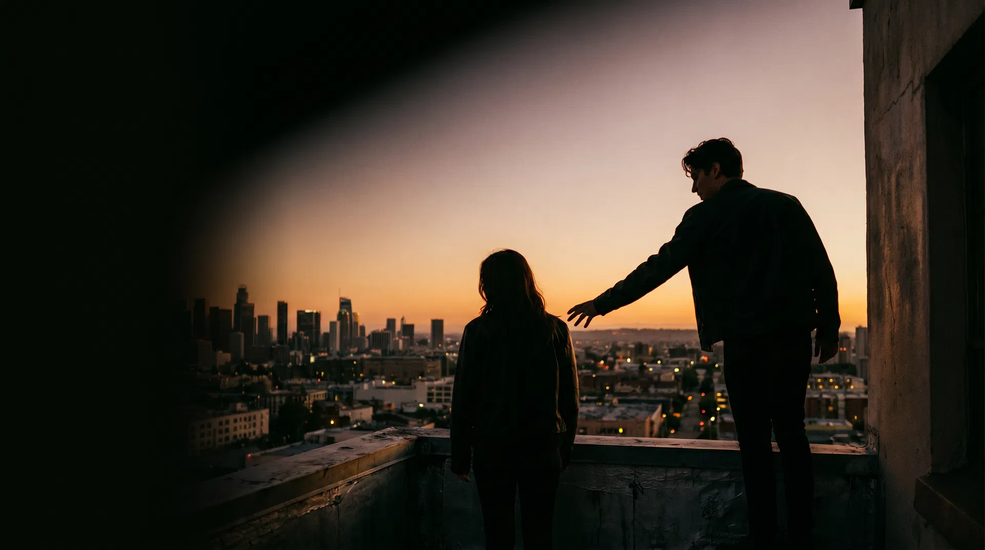 Two people at dusk on a city rooftop