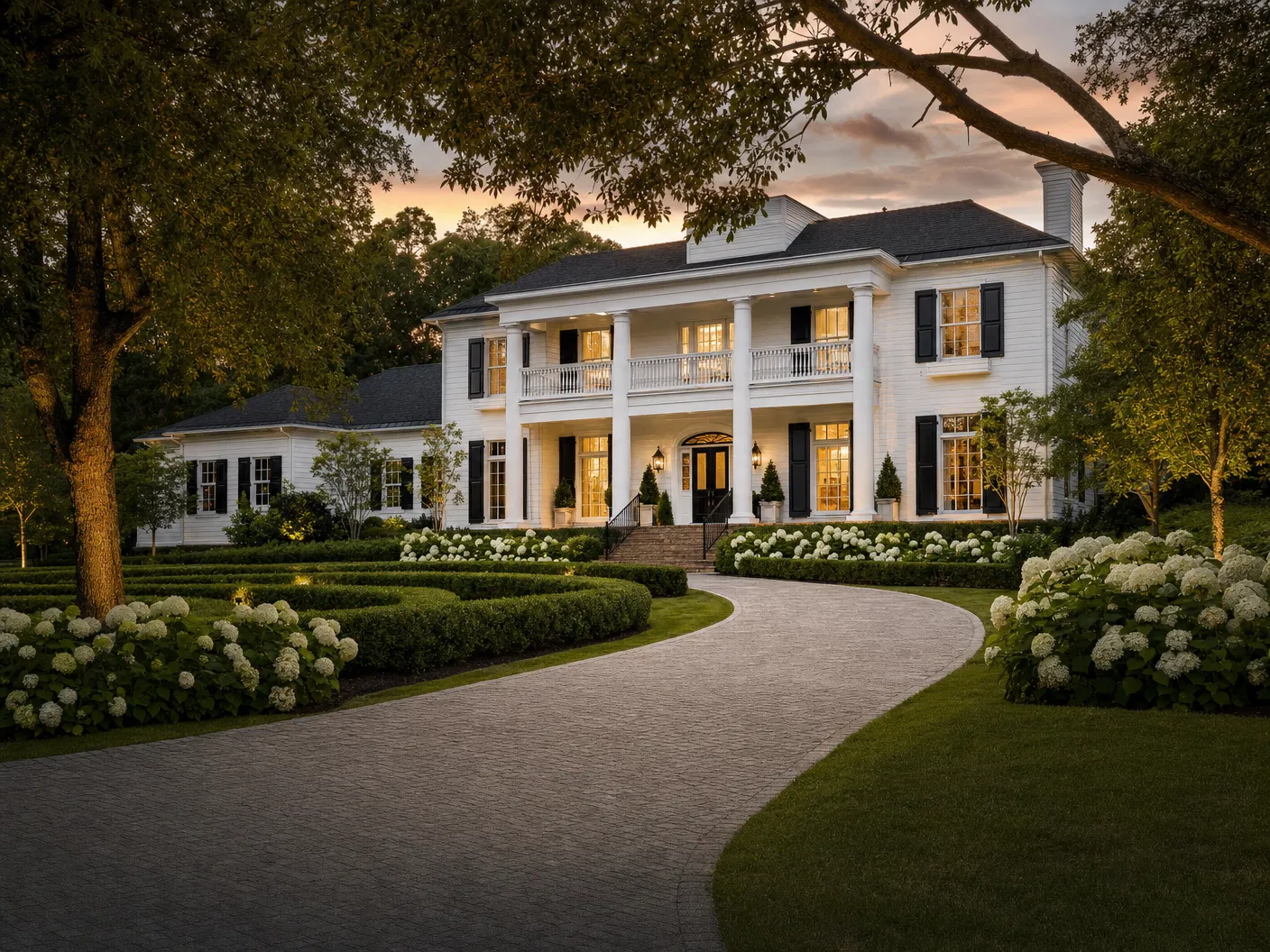 Colonial home with paver driveway and hydrangeas