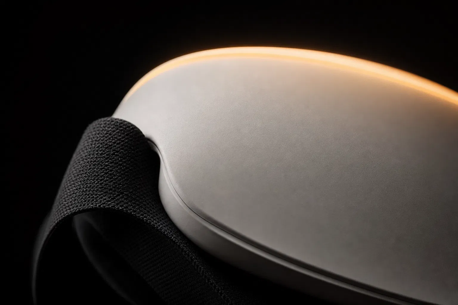 Macro detail of pearl mask material, black strap, and warm amber edge glow
