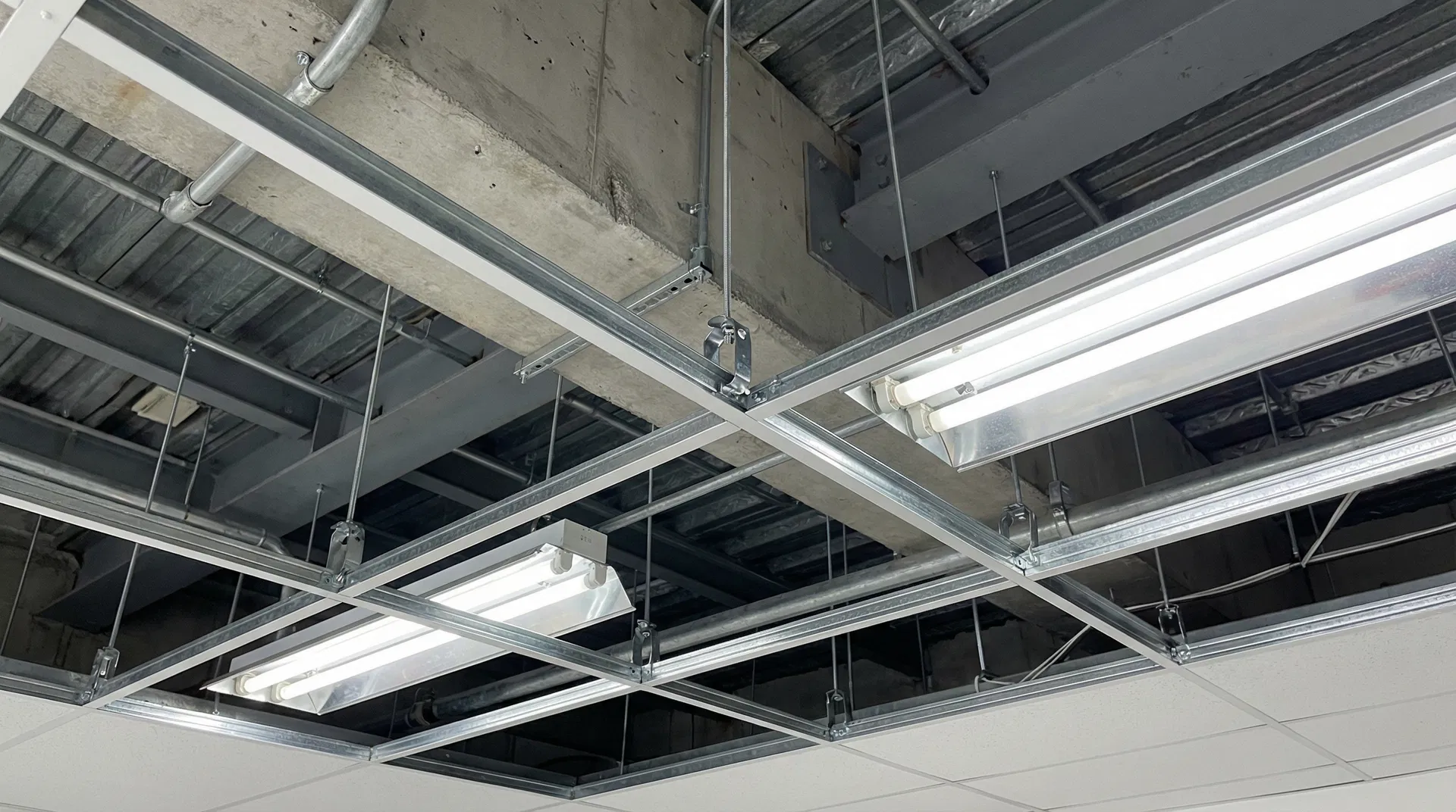 Suspended ceiling grid system showing seismic bracing wires and restraint clips in a commercial building