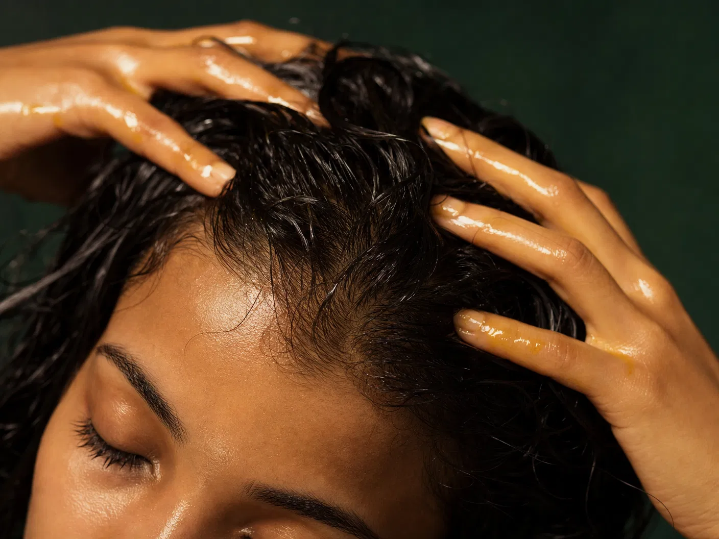 Person massaging Batana oil into scalp