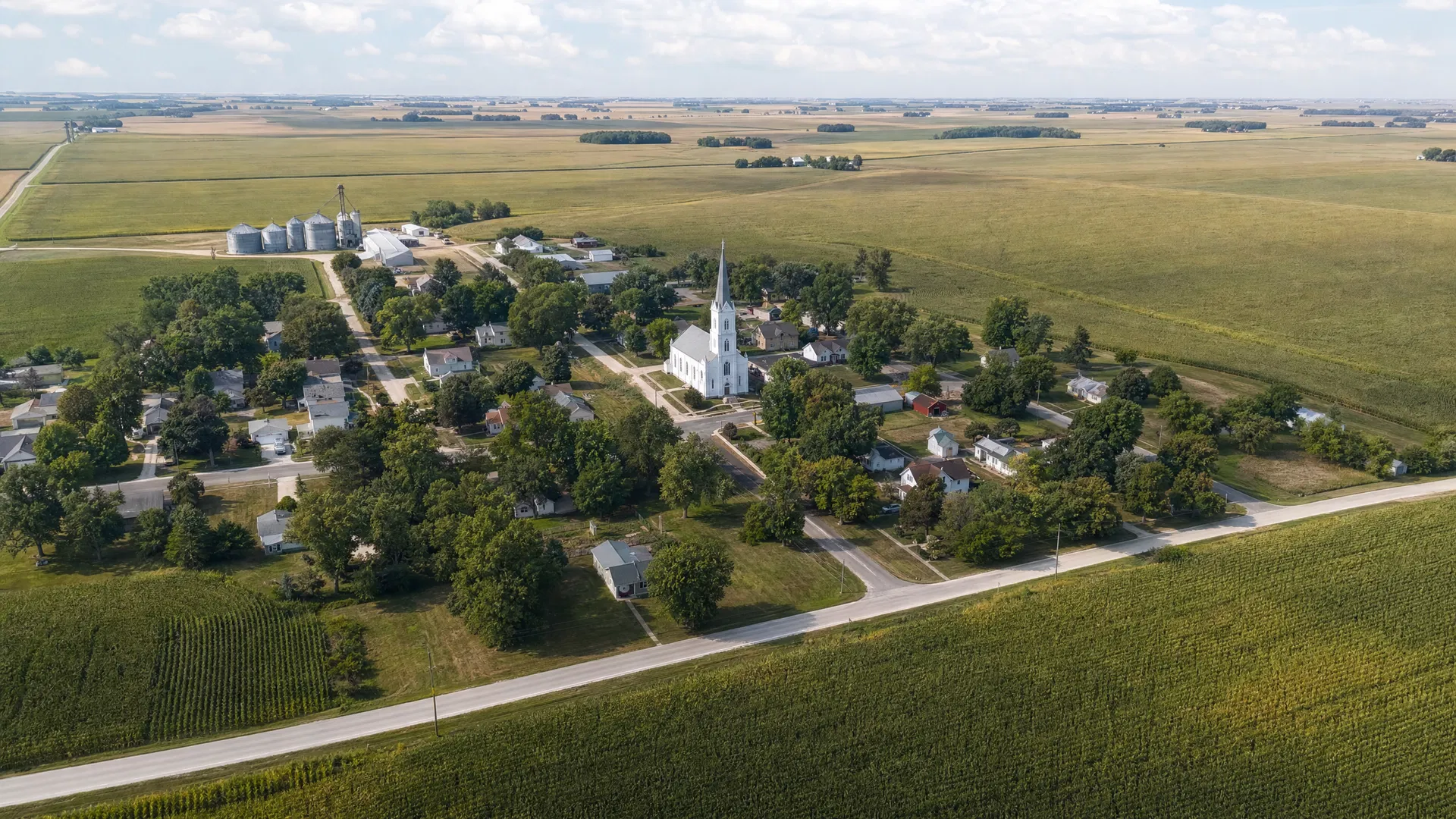 Ireton, Iowa aerial view of small farming village with white church surrounded by cornfields