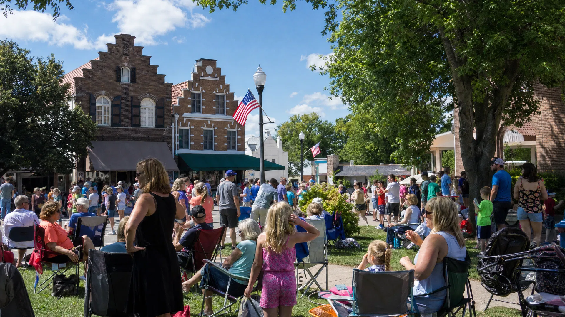 Iowa small-town community gathering at an outdoor festival with Dutch-style architecture